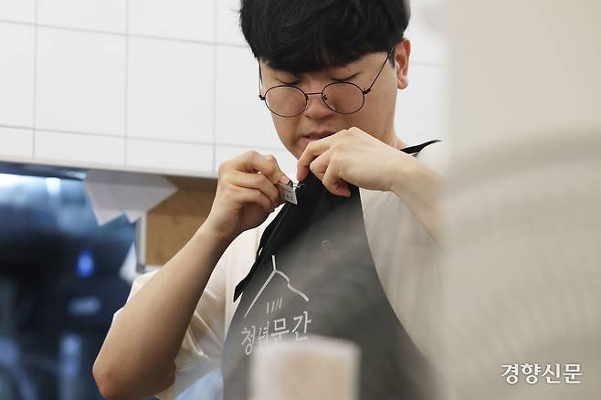 혜화 슬로우점에서 일하는 임예찬씨가 식당 영업 준비를 하며 명찰을 달고 있다.