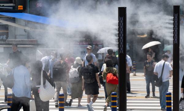 전국 대부분 낮 기온 30도 이상 무더위인  동구 부산역 앞 횡단보도에 선 시민과 관광객들이 쿨링포그를 맞고 있다. 전민철 기자 jmc@kookje.co.kr