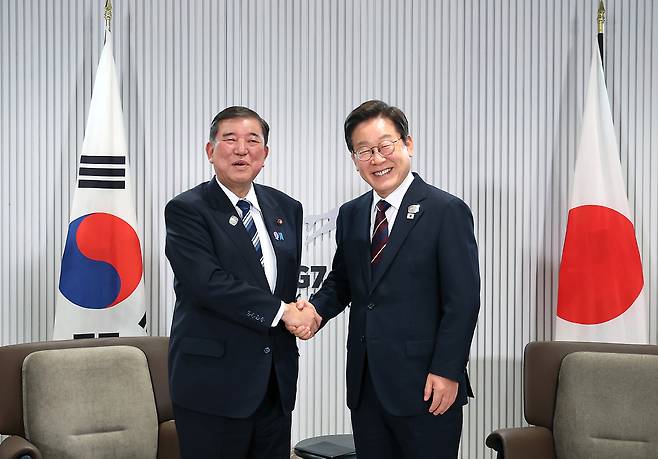 President Lee Jae Myung, right, shakes hands with Japanese Prime Minister Shigeru Ishiba in their first bilateral talks on the margins of the Group of 7 summit in Calgary, Canada, on June 17. [JOINT PRESS CORPS]