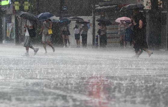 Pedestrians in Jongno District, central Seoul, use umbrellas amid heavy rain across Korea's capital on July 8. [NEWS1]
