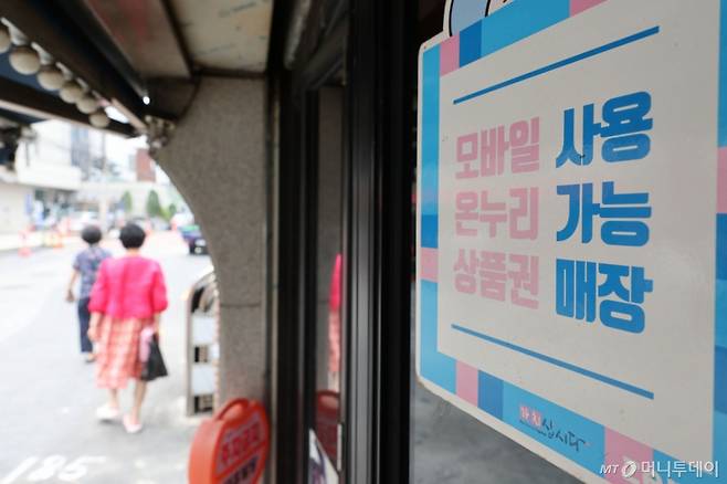 [서울=뉴시스] 권창회 기자 = 경기 부양을 위한 이재명 정부의 첫 민생회복 소비쿠폰이 오는 21일부터 지급된다. 1차로 우선 15만~45만원을 지급하며, 9월 22일부터 소득 상위 10%를 제외한 국민 90%에게 10만원을 추가 지급할 예정이다. 난민 인정자도 받을 수 있으며 대형마트, 명품관, 배달앱 등에서의 사용은 제한된다.   사진은 7일 서울 시내 전통시장 내 지역화폐 결제 가능 매장의 모습. 2025.07.07. kch0523@newsis.com /사진=권창회