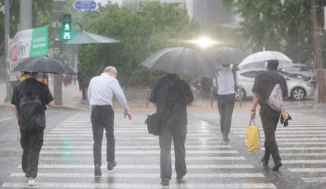 서울 서남권에 호우주의보가 발효된 8일 서울 영등포구 여의도 국회 인근에서 시민들이 우산을 쓰고 이동하고 있다. 연합뉴스