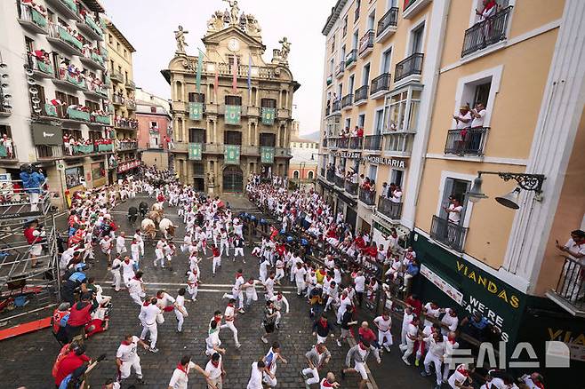 [팜플로나=AP/뉴시스] 7일(현지 시간) 스페인 팜플로나에서 열린 연례 산 페르민 축제 중 황소와 달리기(엔시에로) 참가자들이 골목길을 달리고 있다. 2025.07.07.
