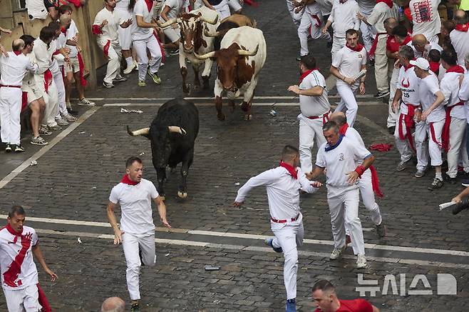 [팜플로나=AP/뉴시스] 7일(현지 시간) 스페인 팜플로나에서 열린 연례 산 페르민 축제 중 황소와 달리기(엔시에로) 참가자들이 골목길을 달리고 있다. 2025.07.07.