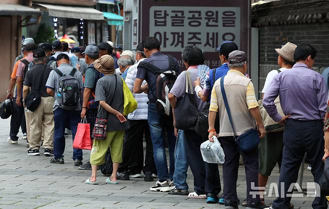 [서울=뉴시스] 최진석 기자 = 서울 전역에 올여름 첫 폭염경보가 내려진 7일 서울 탑골공원 인근에서 어르신들이 무료급식을 위해 줄지어 대기하고 있다. 2025.07.07. myjs@newsis.com