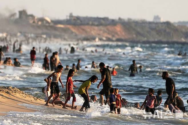 [가자시티=AP/뉴시스] 지난 2일(현지 시간) 가자시티 팔레스타인 피란민들이 지중해에서 물놀이를 하며 더위를 식히고 있다. 2025.07.08.