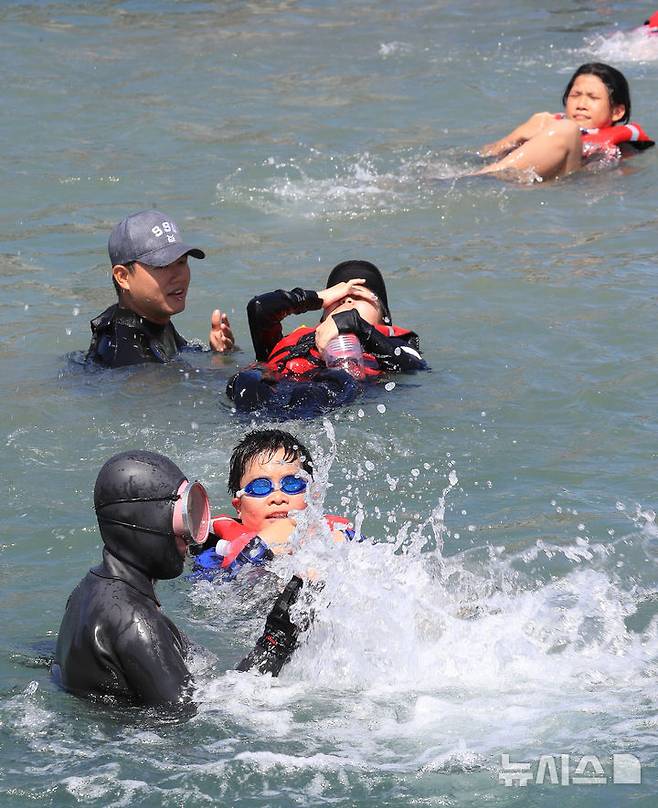 [서귀포=뉴시스] 우장호 기자 = 8일 오전 제주 서귀포시 법환 해녀체험장에서 제주도교육청과 해녀·해군기동함대사령부가 협동해 강정초등학교 학생들에게 '제주형 생존수영' 교육을 하고 있다. 이번 생존수영 교육은 법환 어촌계 해녀, 해군 해난구조대(SSU)가 함께하는 전국 최초의 프로그램으로 서귀포시 관내 초등학교 5~6학년 학생 100여명(3개교)을 대상으로 8월15일까지 운영된다. 2025.07.08. woo1223@newsis.com