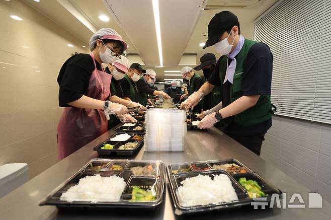 [서울=뉴시스] 권창회 기자 = 염영남 뉴시스 대표이사를 비롯한 직원들이 8일 서울 용산구 가톨릭사랑평화의집에서 도시락 배달 봉사를 하기 위해 음식을 포장하고 있다. 2025.07.08. kch0523@newsis.com