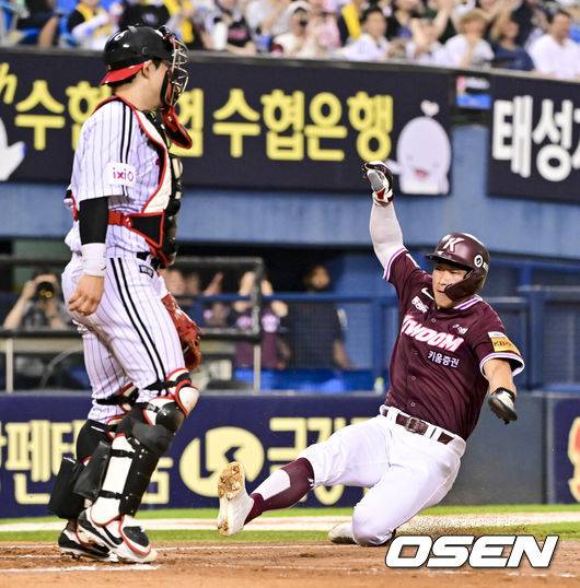 [OSEN=잠실, 박준형 기자] 8일 오후 서울 잠실구장에서 ‘2025 신한 SOL BANK KBO리그’ LG 트윈스와 키움 히어로즈의 경기가 진행됐다.이날 경기에서 LG는 임찬규(8승 3패)를, 키움은 하영민(6승 8패)을 선발투수로 내세웠다.4회초 2사 키움 어준서의 내야안타때 2루 주자 주성원이 LG 신민재 2루수의 송구실책을 틈타 홈 슬라이딩을 하고 있다.    2025.07.08 /  soul1014@osen.co.kr