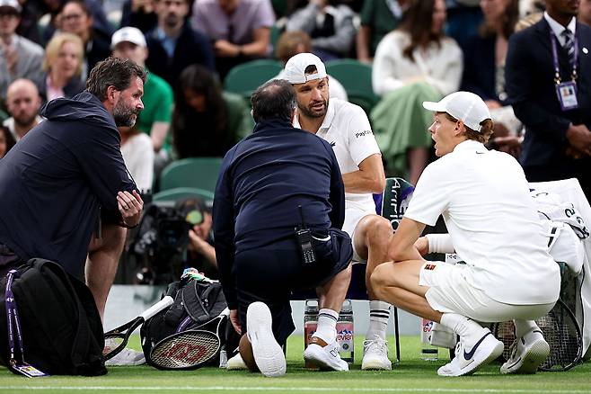 얀니크 신네르(오른쪽)이 7일(현지 시간) 영국 런던의 올잉글랜드 클럽에서 열린 윔블던 16강전 도중 치료를 받는 그리고르 디미트로프 상황을 지켜보고 있다. 게티이미지코리아