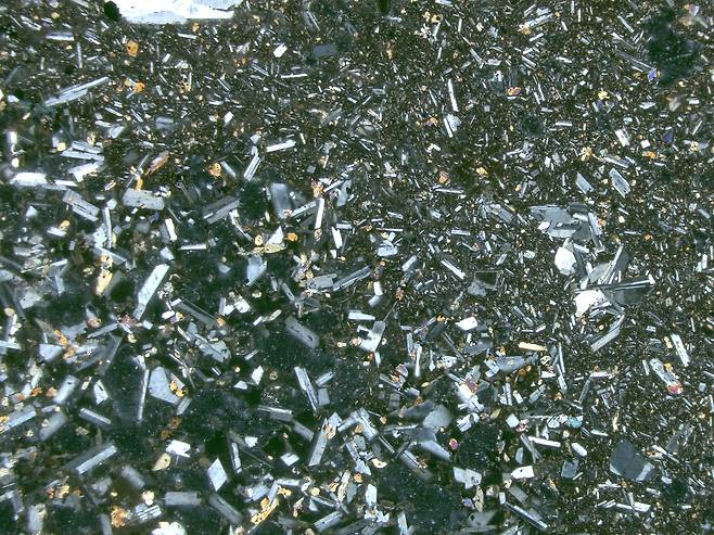 칠레 모초-초슈엔코 화산암 절편의 편광현미경 사진 칠레 안데스산맥의 휴화산 모초-초슈엔코에서 채취한 암석을 30㎛ 두께로 잘라 편광현미경으로 관찰한 사진. 한때 용암이었던 이 암석 속 다양한 광물들이 각기 다른 색과 형태를 띠고 있다. [Pablo Moreno-Yaeger / UW-Madison 제공. 재판매 및 DB 금지]