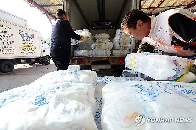 얼음 옮기는 작업자들 (담양=연합뉴스) 김혜인 기자 = 연일 폭염 특보가 이어진 8일 오전 전남 담양군 봉산면 한 얼음공장에서 작업자들이 트럭에 얼음을 싣고 있다. 2025.7.8 in@yna.co.kr