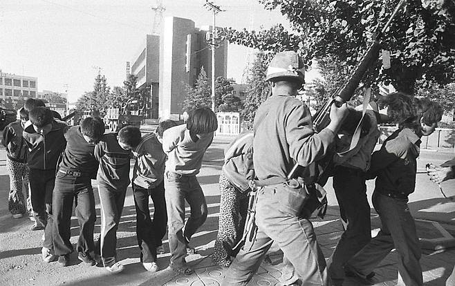 1980년 5월 27일 옛 전남도청에서 계엄군이 시민들을 체포해 연행하는 모습을 프랑스 외신기자가 촬영한 사진. 5·18 기동타격대동지회 제공