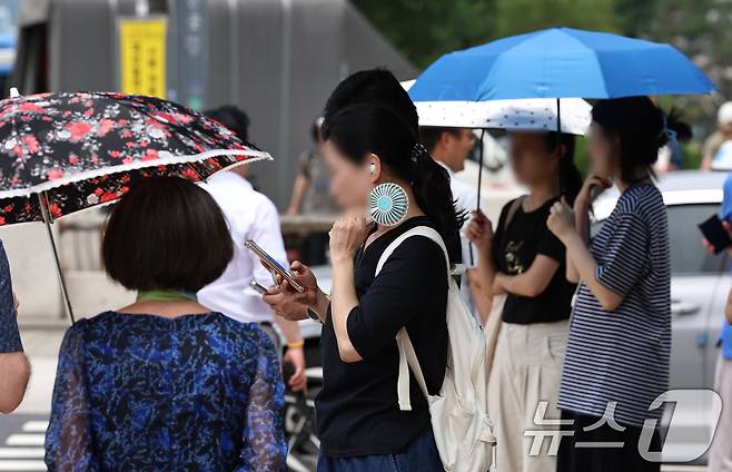 무더위가 이어지는 3일 오후 서울 도심에서 시민들이 휴대용 선풍기와 양산 등으로 저마다 더위를 식히고 있다. 2025.7.3/뉴스1 ⓒ News1 구윤성 기자
