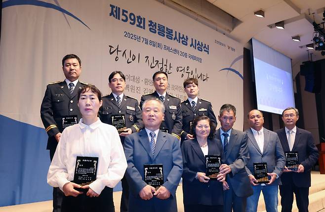 8일 서울 프레스센터에서 열린 제59회 청룡봉사상 시상식에서 수상자들이 상패를 들고 있다. 앞줄 왼쪽부터 고(故) 곽한길씨 아내 오승현씨, 백원진 경정 부친 백옥현씨, 황영숙·이대성 부부, 수기안토씨가 살던 경북 영덕군 축산면 경정3리의 어촌계장 유명신씨, 하상훈 생명의전화 원장. 뒷줄 왼쪽부터 신진훈 경위, 이율학 경사, 김영봉 경감, 김정원 경사. 올해 수상자 중 백원진 경정은 캄보디아에, 수기안토씨는 인도네시아에 있어 백씨와 유씨가 대신 참석했다./장경식 기자