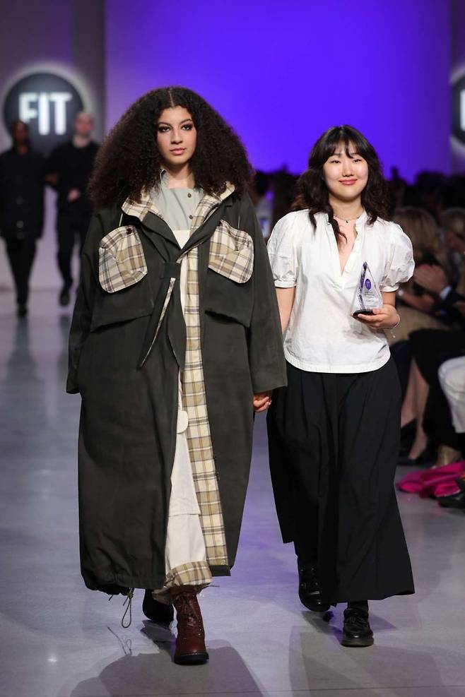 지난해 FIT(패션공과대학교) 졸업 당시 critic awards를 수상하고, 패션쇼무대에 모델과 함께 오른 김남우 디자이너(오른쪽).