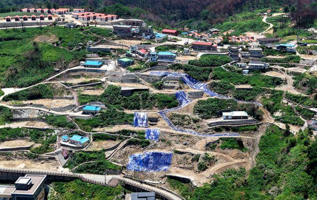 경북 산불 발생 100일째이던 지난달 30일 경북 영덕군 영덕읍 석리 따개비 마을에 산불로 전소된 주택이 모두 철거되고 낙석과 산사태 방지를 위한 방수포가 덮여있다. 영덕=뉴시스