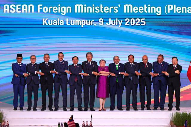 9일 말레이시아 쿠알라룸푸르에서 열린 아세안 외교장관 회의 참석자들이 손을 맞잡고 기념사진을 촬영하고 있다. 쿠알라룸푸르=EPA 연합뉴스
