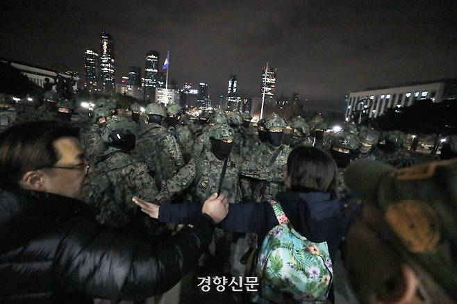 윤석열 전 대통령의 비상계엄을 선포한 다음 날인 지난해 12월 4일 계엄군이 서울 여의도 국회 본관으로 진입을 시도하자 시민들이 서로 손을 잡고 저지하고 있다. 한수빈 기자