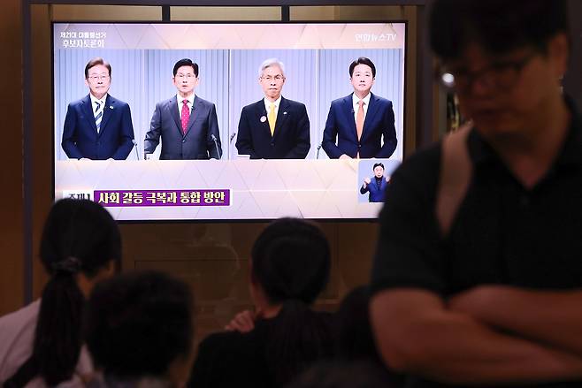 People watch the second presidential election debate in the waiting area of Seoul Station in central Seoul on May 23. [YONHAP]