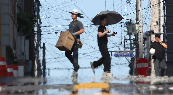 A worker moves supplies near a construction site in Daegu on July 9, as record-breaking heatwaves swept the country. [YONHAP]