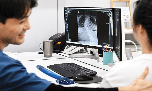 희소질환인 '루빈스타인-테이비 증후군'을 앓고 있는 박하진양의 척추는 37도나 휘었다. 지난달 24일 의료진이 엑스레이 사진을 보며 진료를 하고 있다. 부평그린마취통증의학과의원은 박양의 진료비와 재활 치료비 전액을 지원하고 있다.