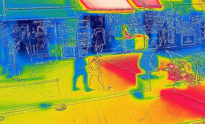 폭염이 이어지고 있는 9일 문을 열어둔 채 냉방 중인 서울 중구 명동 매장을 열화상 카메라로 촬영한 모습. 온도가 높은 곳은 붉게, 낮은 곳은 푸르게 표시돼 있다. [사진 = 연합뉴스]