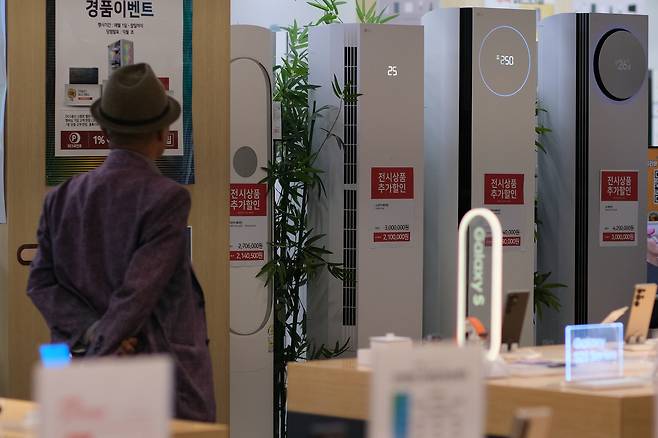 서울 시내 대형마트에서 한 시민이 에어컨 및 냉방용 가전제품을 살펴보고 있다. [연합]