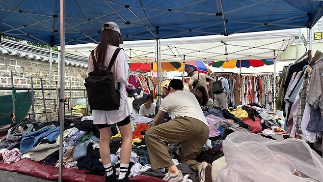 서울 종로구 ‘동묘 벼룩시장’을 찾은 시민이 옷을 고르고 있다.  박연수 기자