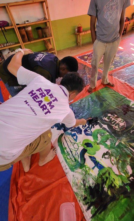 [사진=박현주 미술전문기자] 김남표 작가가 아이들이 칠해 놓은 그림 위에 CDP센터 선생님과 함께 배틀하듯  덧입히며 거대한 추상화를 완성하고 있다. *재판매 및 DB 금지