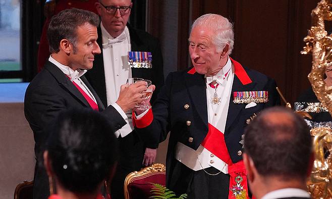 브렉시트(Brexit·영국의 EU 탈퇴) 이후 처음으로 영국을 국빈 방문한 에마뉘엘 마크롱 프랑스 대통령(왼쪽)이 8일(현지시간) 런던 윈저성에서 열린 만찬에서 찰스 3세 영국 국왕과 건배를 하고 있다. 런던=AFP연합뉴스