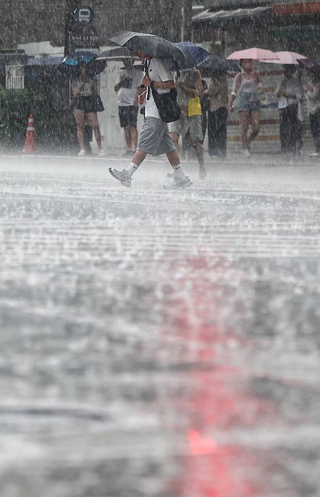 낮엔 폭염, 저녁엔 기습 폭우 - 폭염경보가 내려진 가운데 갑작스러운 폭우가 쏟아진 8일 오후 서울 종로구 종각역 인근에서 시민들이 우산을 쓴 채 이동하고 있다. 이날 서울의 낮기온은 37.8도로 역대 가장 높은 7월 초(1~10일) 기온을 기록했다. 뉴스1