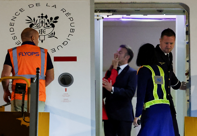 25일(현지시간) 베트남에 도착한 전용기 안에서 에마뉘엘 마크롱 프랑스 대통령의 얼굴을 브리지트 마크롱 여사가 밀고 있다. 2025.5.25 하노이 로이터 연합뉴스