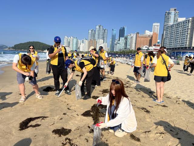 치어리더 이아영이 해운대에서 대만 팬들과 쓰레기를 줍고 있다. 부산관광공사 제공
