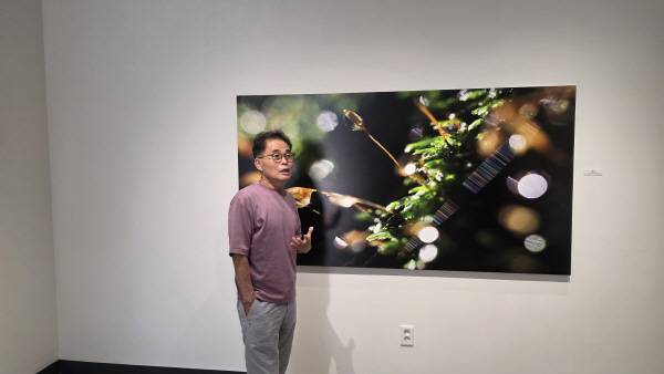 최봉영 JI갤러리 관장이 작품 중 유일하게 이름이 있는 '합창' 작품에 대해 설며하고 있다. 김산호 기자.