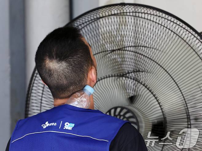 연일 폭염이 이어지고 있는 9일 서울 시내 한 택배물류센터에서 노동자가 택배 분류 작업 중 더위를 식히고 있다. 2025.7.9/뉴스1 ⓒ News1 황기선 기자