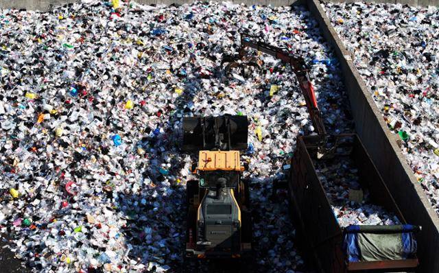 환경의 날인 지난달 5일 경기 수원시자원순환센터에서 관계자들이 가득 쌓인 플라스틱 재활용 쓰레기를 처리하고 있다. 연합뉴스