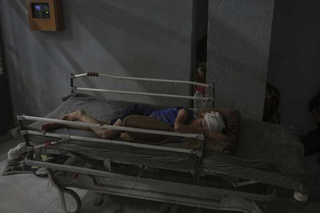 지난 6일(현지시간) 가자지구 가자시티 알시파 병원 복도에서 머리 부상을 입은 아메드 리한(10)이 잠들어 있다. 한 달 전쯤 부상을 입은 그는 병실이 없어 가족과 함께 병원 복도에서 지내고 있다. AP연합뉴스