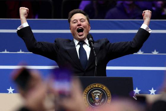 Tesla CEO Elon Musk gestures on stage as he prepares to speak inside the Capital One Arena on the inauguration day of Donald Trump's second presidential term, in Washington on Jan. 20. [YONHAP/ REUTERS]