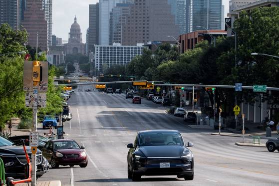 A Tesla robotaxi drives on the street along South Congress Avenue in Austin on June 22. [YONHAP/ REUTERS ]