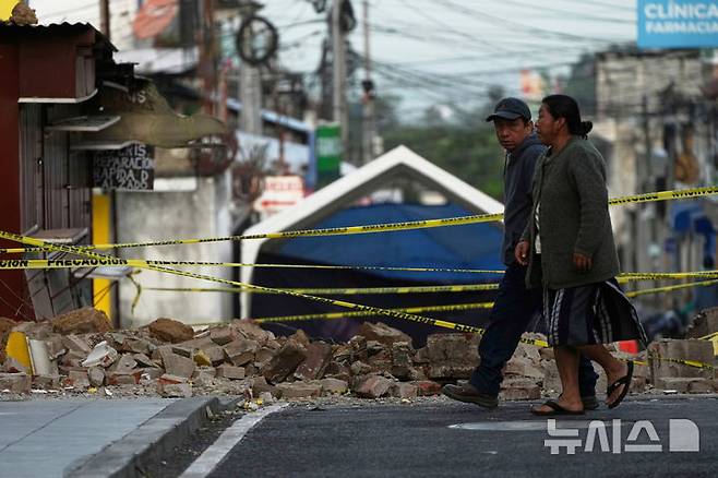 <font style="vertical-align: inherit;"><font style="vertical-align: inherit;">[팔린=AP/뉴시스] 과테말라에서 규모 5.7의 지진이 발생한 가운데 9일(현지 시간) 팔린의 지진 피해 현장 앞으로 주민들이 지나가고 있다. 현지 당국은 지난 8일 오후부터 규모 3.0에서 5.7의 본진과 여진이 150차례 이상 이어지며 최소 4명이 숨졌다고 밝혔다. 2025.07.10.</font></font>