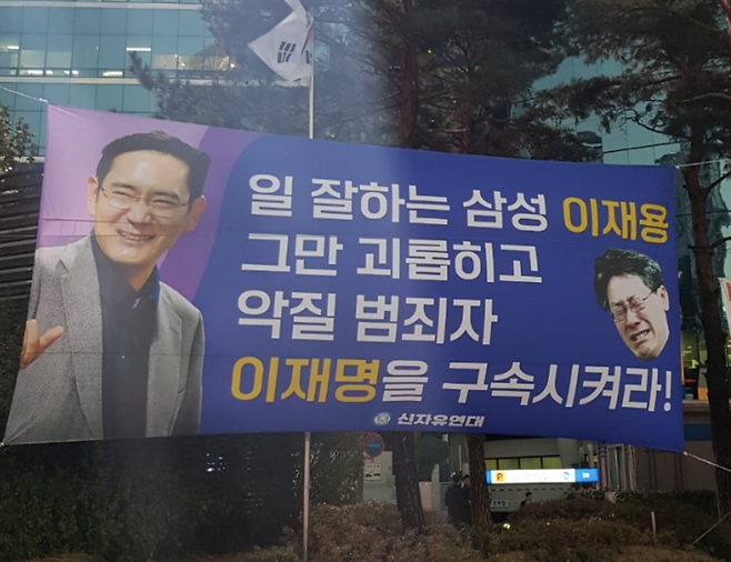 서울 강남역 사거리, 삼성 건물 앞에 걸린 신자유연대 현수막. 삼성 규탄 현수막 게시를 못하게 하기 위해 집회 신고를 선점하고 신자유연대 현수막을 게시했다.