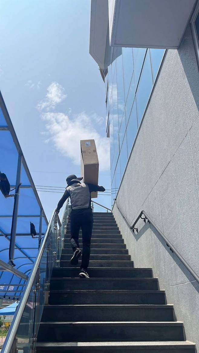박현제 씨가 무더위 속 계단을 올라 대형 박스를 배송하고 있다. 송보현 기자