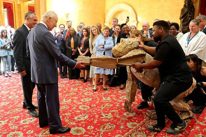 영국 찰스 3세 왕이 지난달 25일 런던 랭카스터 하우스에서 열린 정부 주재 '자연과 기금(Nature and Finance)' 리셉션에서 '더 허즈'의 퍼핏과 인사하고 있다. /AFP연합뉴스