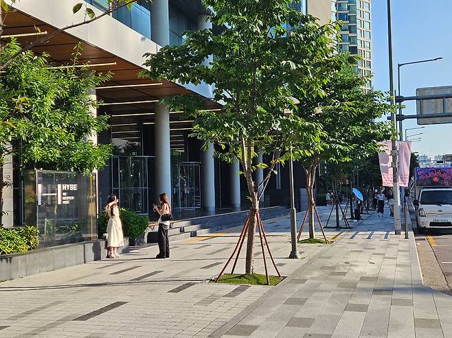 BTS 해외 팬들이 지난 10일 서울 용산 하이브 사옥 앞에서 기념 사진을 촬영하고 있다. 사옥 오른쪽 도로에는 해외 팬들이 보낸 BTS 컴백 축하 뮤직카가 주차돼 있다. /박용선 기자