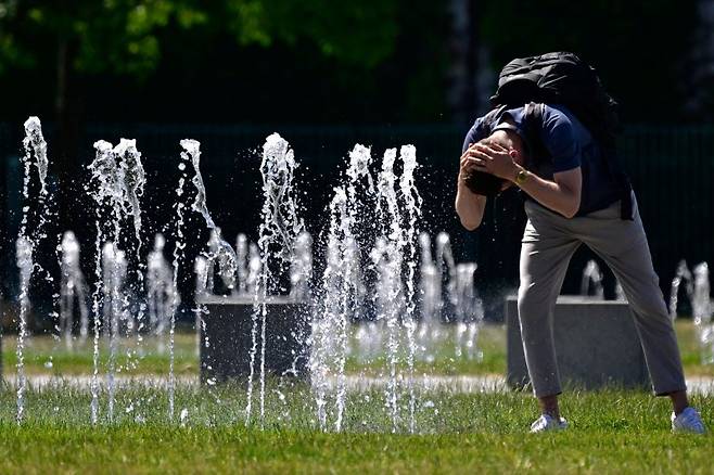 기록적인 초여름 폭염이 유럽 전역으로 확산되고 있는 가운데, 지난 2일 베를린 총리실 앞 분수대에서 한 남성이 더위에 몸에 물을 적시고 있다. AFP 연합뉴스