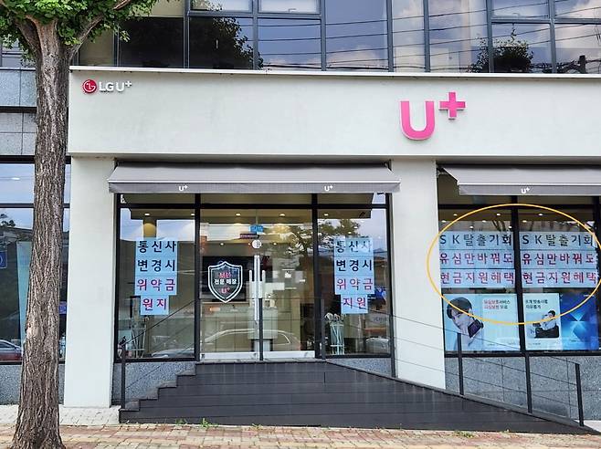 지난 5일 SK텔레콤 매장 바로 옆에 붙어있는 한 LG유플러스 대리점이 'SK탈출기회'라고 적힌 문구를 매장 전면에 내걸고 있다. 사진=독자 제공
