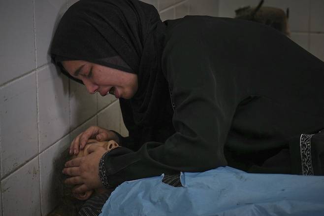 10일(현지시간) 가자지구 데이르 알발라의 의료센터 앞에서 영양 보충제를 기다리던 중 이스라엘의 공습으로 숨진 10명 가운데 한 명인 13세 소녀의 시신 앞에서 가족이 통곡하고 있다. AP연합뉴스