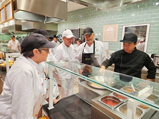 독일 글로버스 현지 조리사들에게 더본코리아 관계자가 컨설팅 하고 있다. [사진 = 더본코리아 제공]