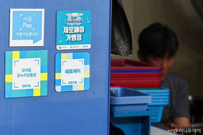 [서울=뉴시스] 권창회 기자 = 경기 부양을 위한 이재명 정부의 첫 민생회복 소비쿠폰이 오는 21일부터 지급된다. 1차로 우선 15만~45만원을 지급하며, 9월 22일부터 소득 상위 10%를 제외한 국민 90%에게 10만원을 추가 지급할 예정이다. 난민 인정자도 받을 수 있으며 대형마트, 명품관, 배달앱 등에서의 사용은 제한된다.   사진은 7일 서울 시내 전통시장 내 지역화폐 결제 가능 매장의 모습. 2025.07.07. kch0523@newsis.com /사진=권창회